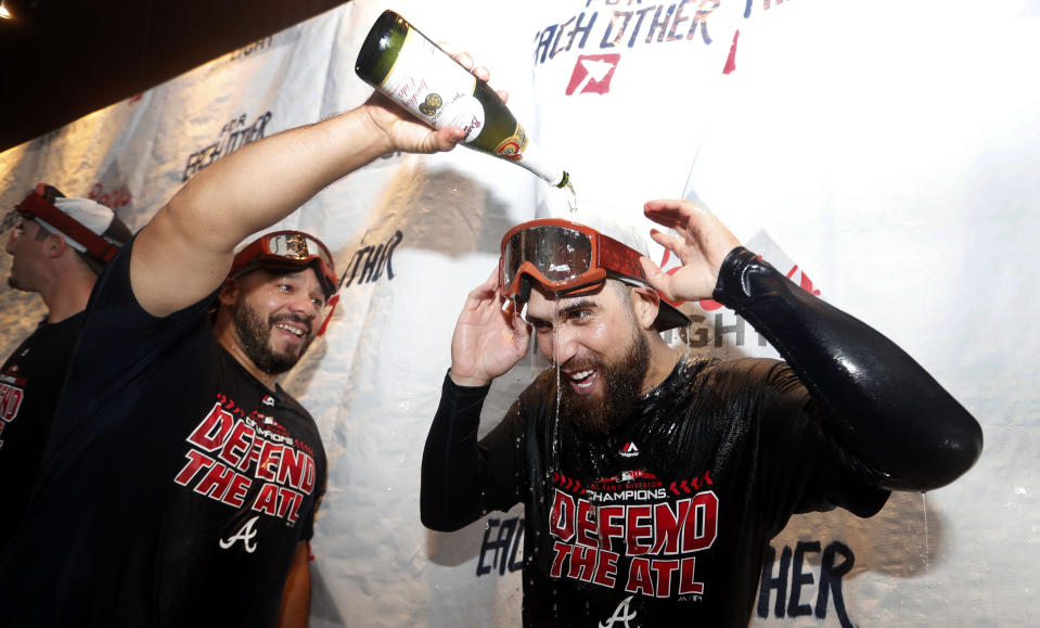 Atlanta Braves catcher Rene Rivera, left, pours champagne on Ender Inciarte as they celebrate after defeating Philadelphia Phillies 5-3 in a baseball game to clinch the National League East Division, Saturday, Sept. 22, 2018, in Atlanta. (AP Photo/John Bazemore).