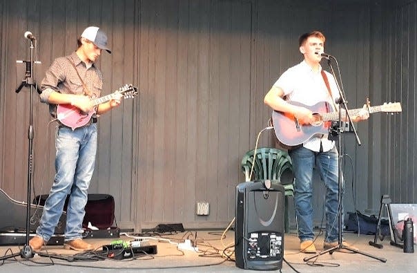 Phin Johnson (left) plays the mandolin and his brother Gus sings and plays guitar during a local performance as Low Gap. The Hiland High School students have recently released their first single.