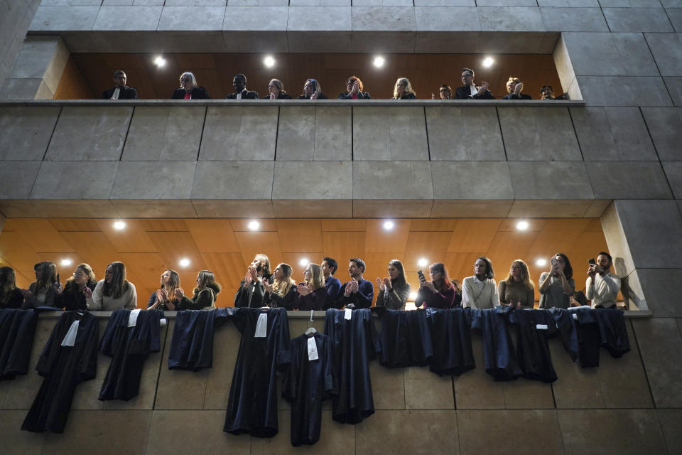 Striking lawyers angry over President Emmanuel Macron's planned overhaul of the French pension system demonstrate while their robes hang at the Lyon court house, central France, Monday Jan.13, 2020. (AP Photo/Laurent Cipriani)