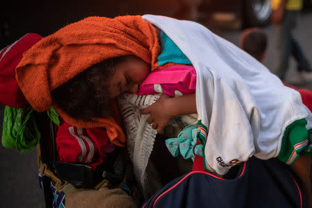 A young migrant, traveling with a caravan of thousands from Central America en route to the United States, sleeps atop baggage resting on a stroller while looking to go to Arriaga from Pijijiapan, Mexico October 26, 2018. REUTERS/Adrees Latif