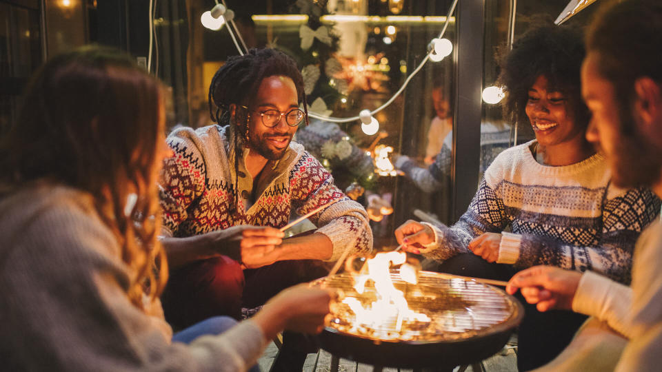 Friends on porch making roasted marshmallow.