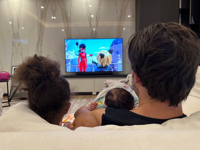 <p>Courtesy of Alexis Ohanian</p> Alexis Ohanian watching TV with Olympia and Adira
