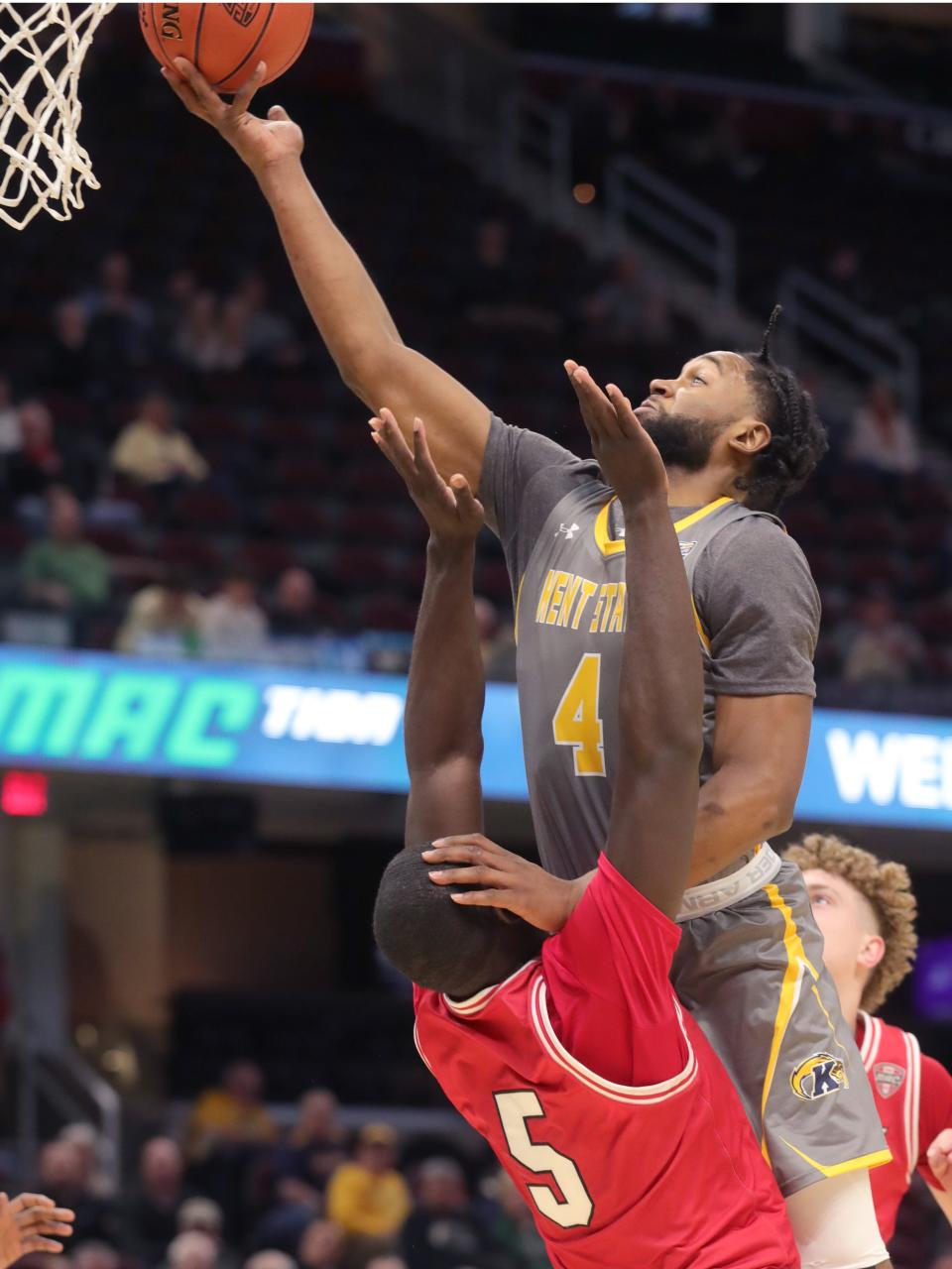 Kent State's Andrew Garcia drives over Miami's Precious Ayah for a second-half basket in a Mid-American Conference Tournament quarterfinal game on Thursday March 10, 2022 in Cleveland, Ohio, at Rocket Mortgage FieldHouse.