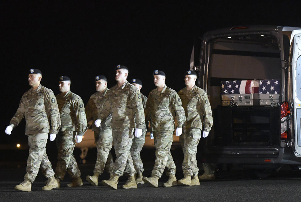 An Army carry team marches away from transfer cases containing the remains of Sgt. 1st Class Antonio Rey Rodriguez, left case, and Sgt. 1st Class Javier Jaguar Gutierrez, right case, Monday, Feb. 10, 2020, at Dover Air Force Base, Del. According to the Department of Defense, Rodriguez, 28, of Las Cruces, N.M., and Gutierrez, 28, of San Antonio, died in Nangarhar province, Afghanistan, of wounds sustained during combat operations. (AP Photo/Steve Ruark)