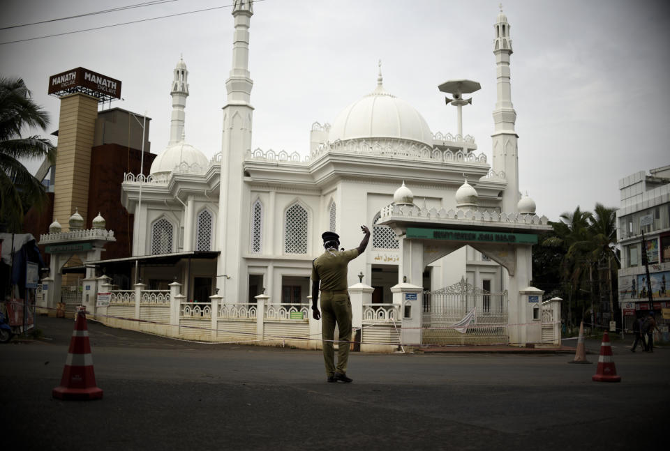 An Indian policeman directs traffic outside a Mosque closed for devotees due to the pandemic lockdown during Ramadan in Kochi, Kerala state, India, Friday, May 22, 2020. Muslims worldwide will celebrate one of their biggest holidays under the long shadow of the coronavirus, with millions confined to their homes and others gripped by economic concerns during what is usually a festive time of shopping and celebration. (AP Photo/R S Iyer)