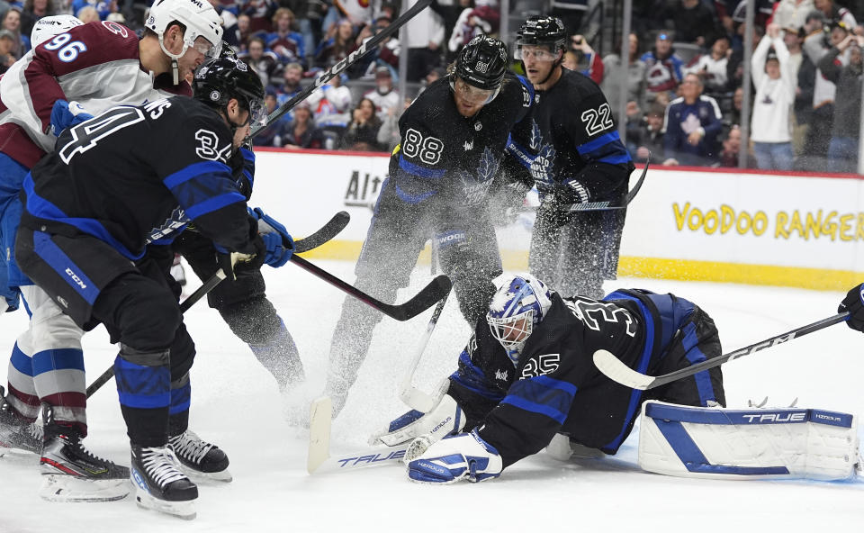 Toronto Maple Leafs goaltender Ilya Samsonov, front right, stops a shot off the stick of Colorado Avalanche right wing Mikko Rantanen, back left, as he drives past Toronto center Auston Matthews, front left, as time runs out in the third period of an NHL hockey game Saturday, Feb. 24, 2024, in Denver. Joining in the play are Toronto right wing William Nylander, center right, and defenseman Jake McCabe. (AP Photo/David Zalubowski)