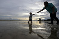 Nikita Pero of Gulfport, Miss., walks with her son Vinny Pero, 2, on the beach along the Gulf of Mexico in Biloxi, Miss., Monday, Sept. 14, 2020. Hurricane Sally is expected to make landfall along the Gulf Coast sometime through the night and morning. (AP Photo/Gerald Herbert)