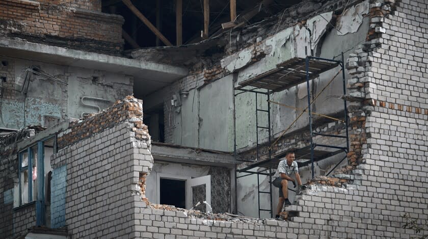 A man looks out from an apartment destroyed after Russian shelling in Nikopol, Ukraine, Monday, Aug. 15, 2022. (AP Photo/Kostiantyn Liberov)