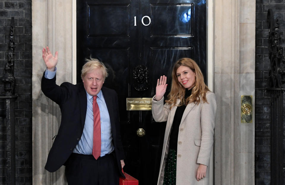 Britain's Prime Minister Boris Johnson and his partner Carrie Symonds gesture as they arrive at 10 Downing Street on the morning after the general election in London, Britain, December 13, 2019. REUTERS/Toby Melville