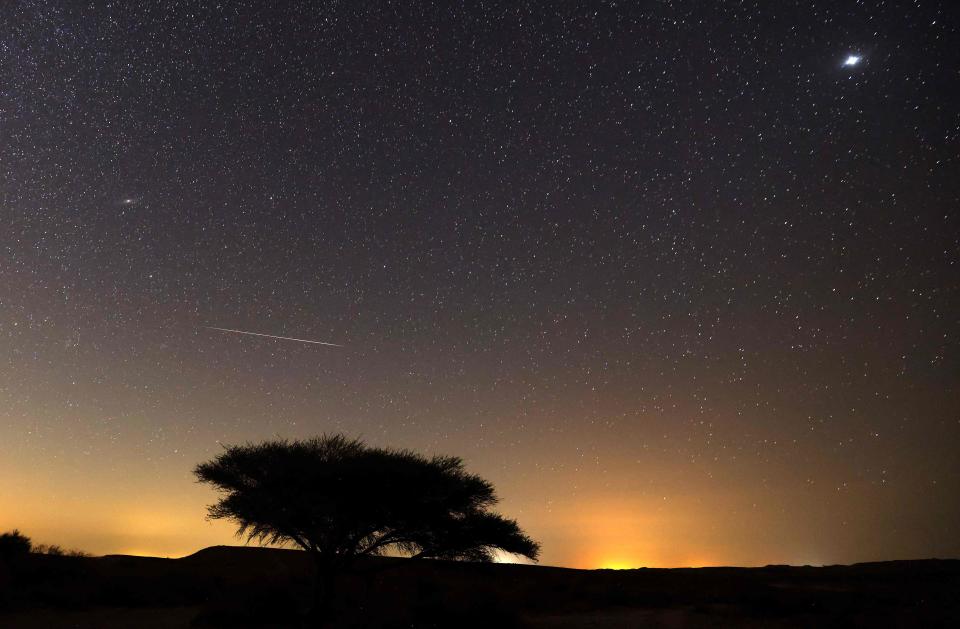 A Perseid meteor in August 2021 streaks across the sky above the Negev desert near the Israeli city of Mitzpe Ramon during a yearly meteor shower, which occurs when the earth passes through the cloud of debris left by the comet Swift-Tuttle.