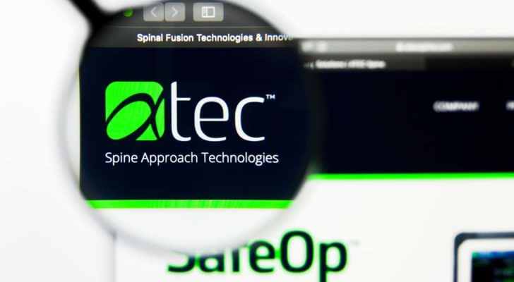 A magnifying glass zooms in on the Alphatec Holdings, Inc. (ATEC) logo