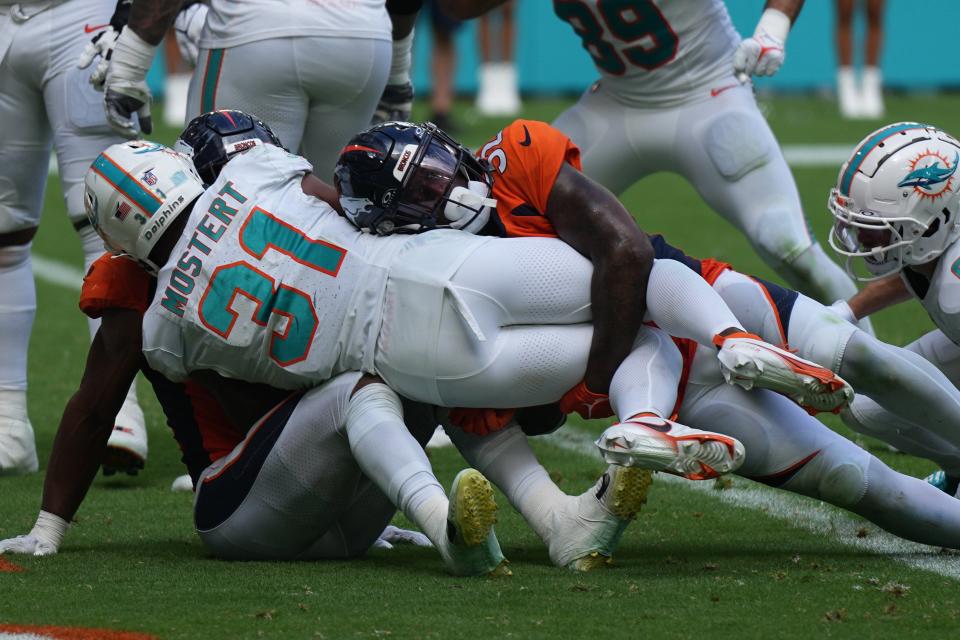 Miami Dolphins running back Raheem Mostert (31) scores a touchdown against Denver Broncos safety Delarrin Turner-Yell (32) during the third quarter of an NFL game at Hard Rock Stadium in Miami Gardens, Sept. 24, 2023.