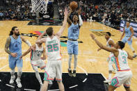 Memphis Grizzlies guard Ja Morant (12) shoots over San Antonio Spurs center Jakob Poeltl (25) during the second half of an NBA basketball game, Wednesday, Jan. 26, 2022, in San Antonio. (AP Photo/Eric Gay)