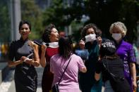 Elderly model group "Glamma Beijing" perform removing face masks during a catwalk in Beijing's CBD area following the coronavirus disease (COVID-19) outbreak