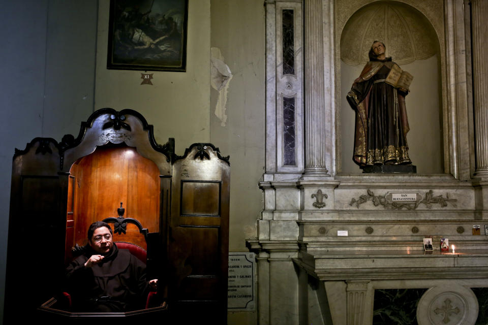 A Franciscan priest waits in a confessionary at the San Francisco Catholic church in Santiago, Chile, Tuesday, Oct. 2, 2018. The archbishop of the Chilean capital went before a local prosecutor Wednesday but declined to testify as a defendant about allegations he covered up years of child sex abuse committed by clerics and officials of the country's Catholic Church. (AP Photo/Esteban Felix)