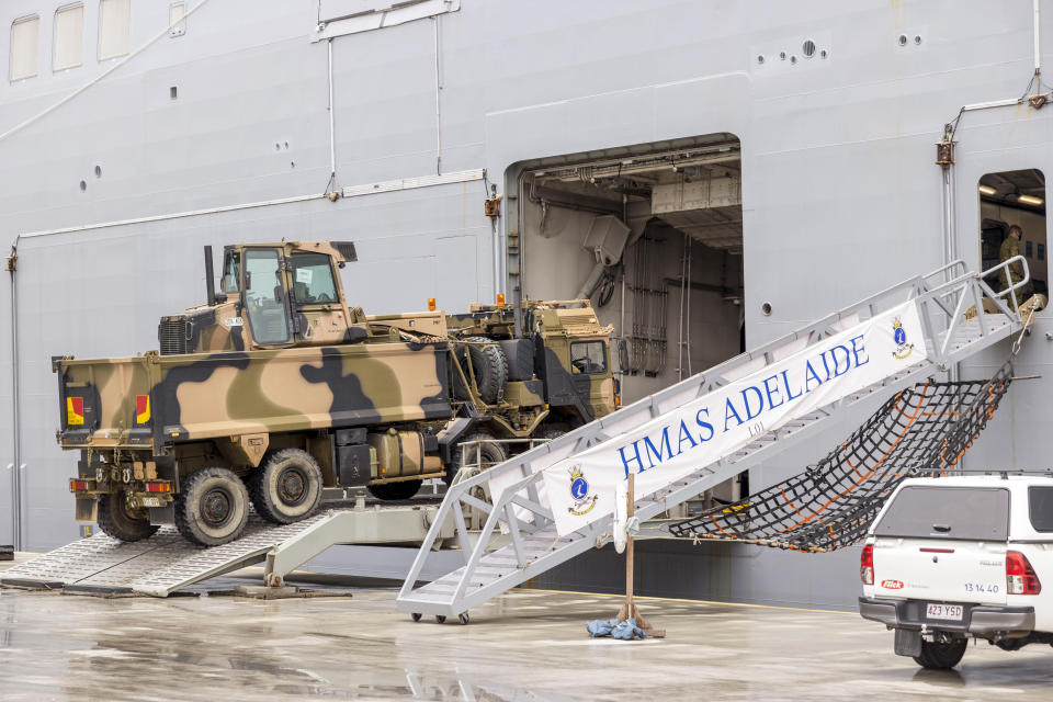 In this photo provided by the Australian Defence Force, vehicles are loaded onto HMAS Adelaide at the Port of Brisbane before departing for Tonga Thursday, Jan. 20, 2022, after a volcano eruption. U.N. humanitarian officials report that about 84,000 people — more than 80% of Tonga's population — have been impacted by the volcano's eruption. (Cpl. Robert Whitmore/Australia Defence Force via AP)