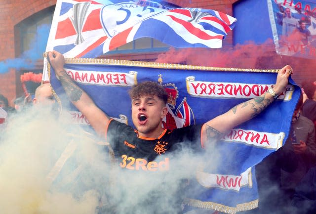 A Rangers fan holds a flag aloft