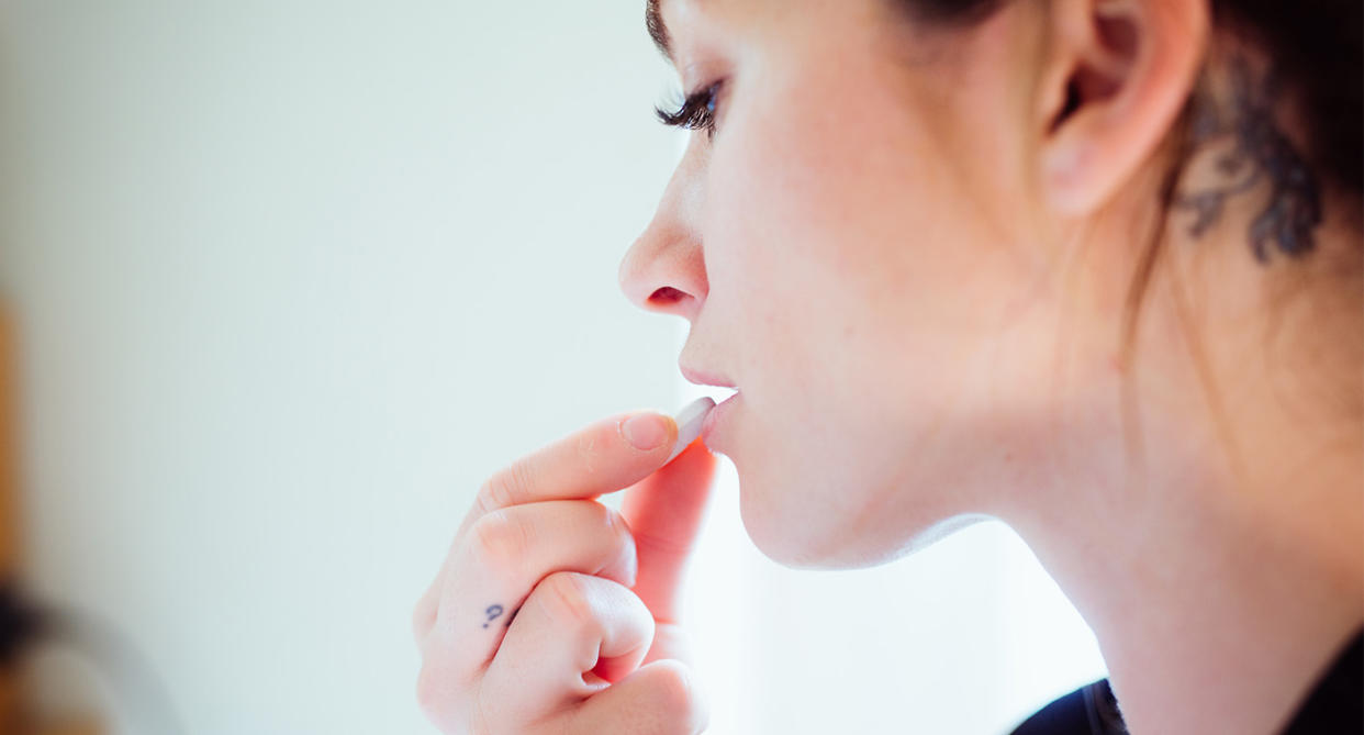 Woman taking vitamin D tablet. (Getty Images)