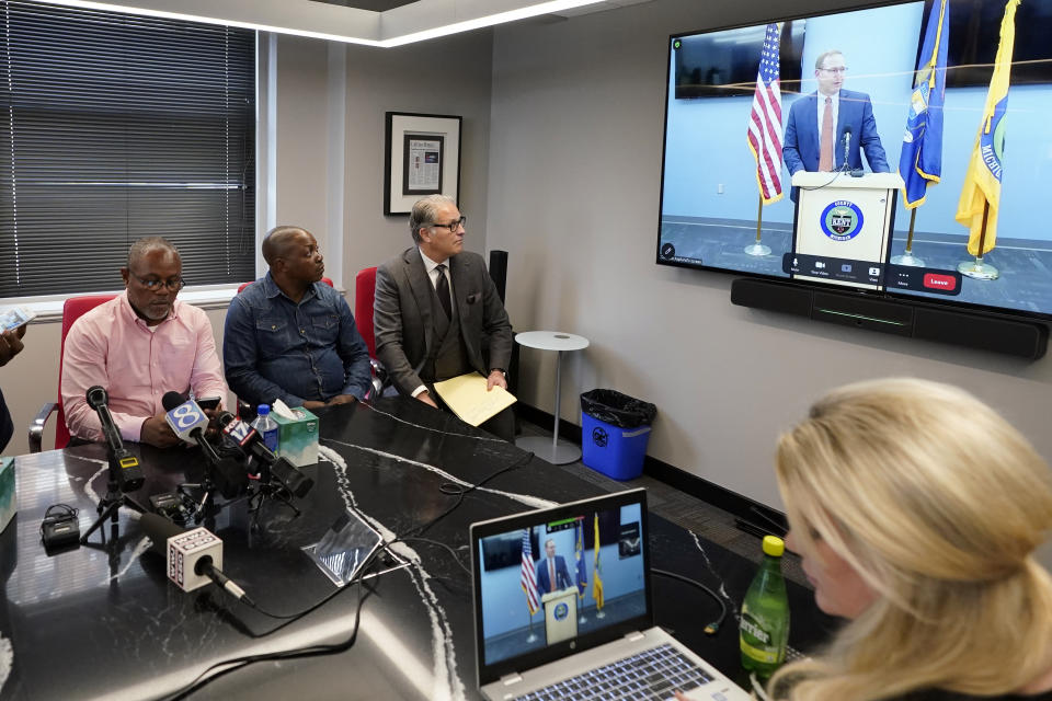 From left, interpreter Israel Siku, Peter Lyoya, and attorney Ven Johnson watch, Thursday, June 9, 2022, in Detroit as Kent County Prosecutor Chris Becker explains his decision to charge Grand Rapids police Officer Christopher Schurr with second-degree murder during a press conference at the Michigan State Police sixth district headquarters in Walker. Schurr fatally shot Black motorist Patrick Lyoya on April 4. (AP Photo/Carlos Osorio)