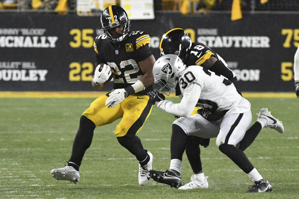 Pittsburgh Steelers running back Najee Harris (22) gets a block by teammate Diontae Johnson (18) against Las Vegas Raiders safety Duron Harmon (30) during the second half of an NFL football game in Pittsburgh, Saturday, Dec. 24, 2022. (AP Photo/Fred Vuich)