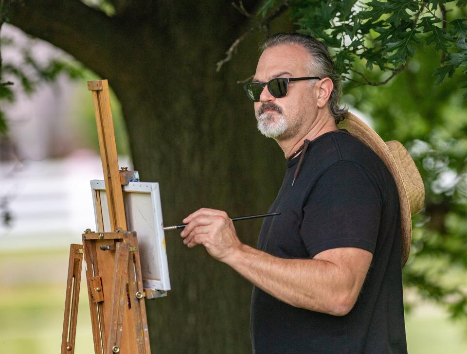 Justin Collamore of Upper Arlington concentrates on his oil painting of the Gantz House June 25.