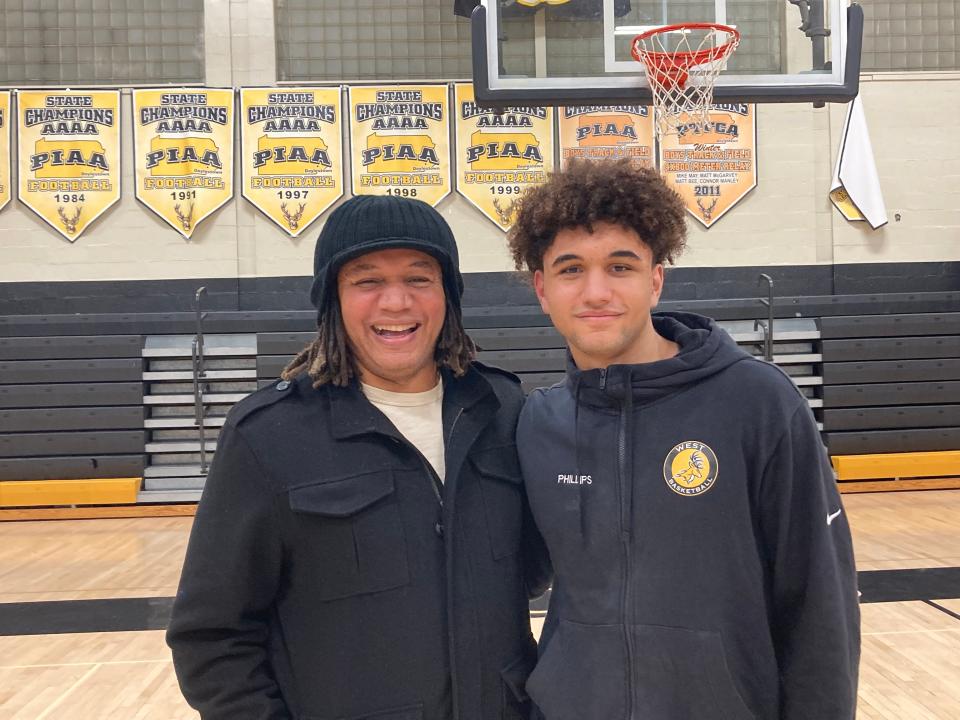 Former Central Bucks West boys basketball standout Thomas Phillips, left, and son Julian Phillips share a moment after Wednesday's home win over Quakertown.