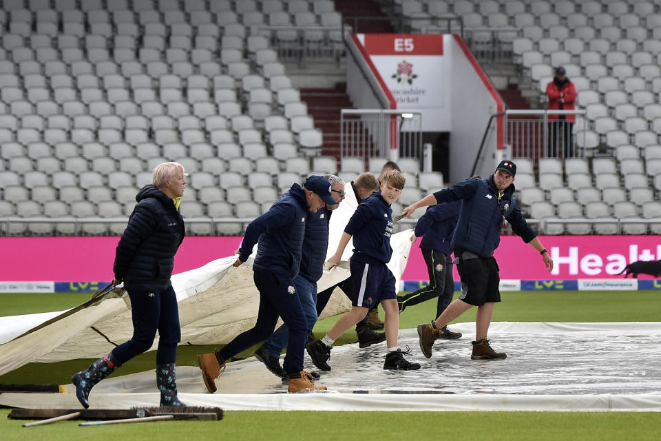 Ground staff put a cover on the pitch on the fifth day of the fourth Ashes Test match between England and Australia at Old Trafford, Manchester, England, Sunday, July 23, 2023. (AP Photo/Rui Vieira)