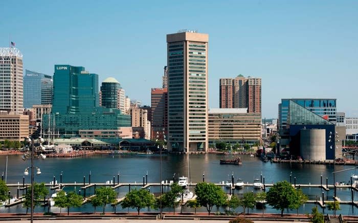 Skyline view of a city's waterfront with modern buildings and a clear sky, depicting a travel destination