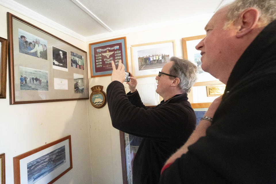 Foreign Secretary Lord David Cameron takes a photograph of a photograph of former Foreign Secretary Douglas Hurd at Goose Green on the Falkland Islands, during his high-profile visit to demonstrate they are a "valued part of the British family" amid renewed Argentinian calls for talks on their future, in Stanley, Falkland Islands, Britain, on Monday Feb. 19, 2024. (Stefan Rousseau/PA via AP)