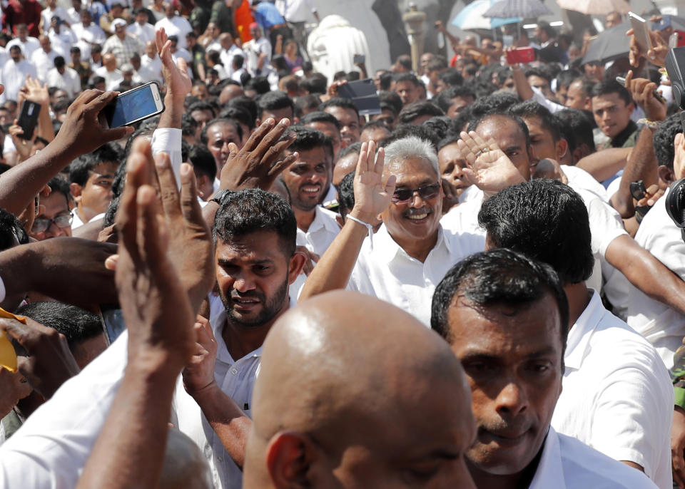 Sri Lanka's newly elected president Gotabaya Rajapaksa, center right, greets people as he leaves after taking the oath of office during the swearing in ceremony held at the 140 B.C Ruwanweli Seya Buddhist temple in ancient kingdom of Anuradhapura in northcentral Sri Lanka Monday, Nov. 18, 2019. The former defense official credited with ending a long civil war was Monday sworn in as Sri Lanka’s seventh president after comfortably winning last Saturday’s presidential election. (AP Photo/Eranga Jayawardena)