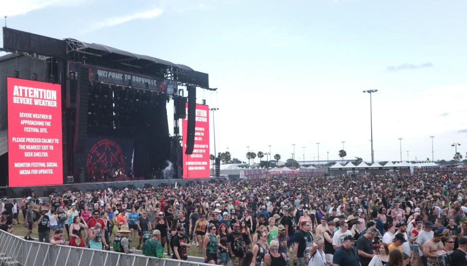 Bright red weather warning signs light up the main stage on Thursday at the Welcome to Rockville music festival at Daytona International Speedway.