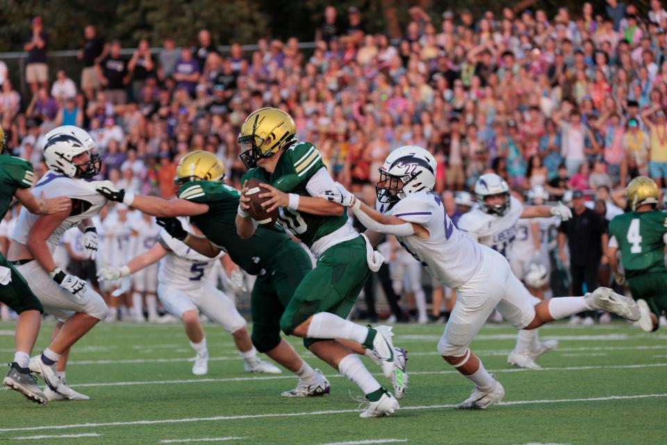 West High's Jack Wallace evades Liberty High's Brady Cannon during their game at West High on Friday, Aug. 25, 2023. (David Scrivner for the Press-Citizen)