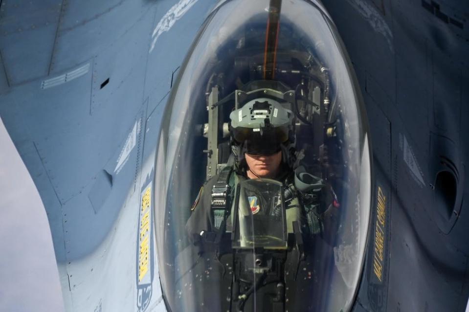 a fighter pilot sits in the cockpit of an aircraft mid-flight