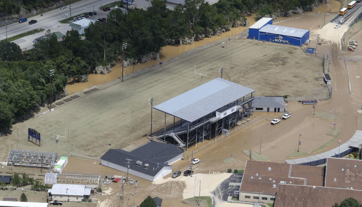 In this aerial image, the football field at Breathitt County High School on Saturday, July 30, 2022, is covered in mud after historic rains flooded many areas of Eastern Kentucky killing multiple people. A thin film of mud from the retreating waters covers many cars and homes.