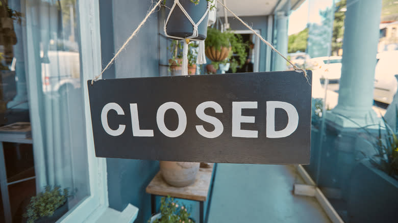 Closed sign hanging by restaurant