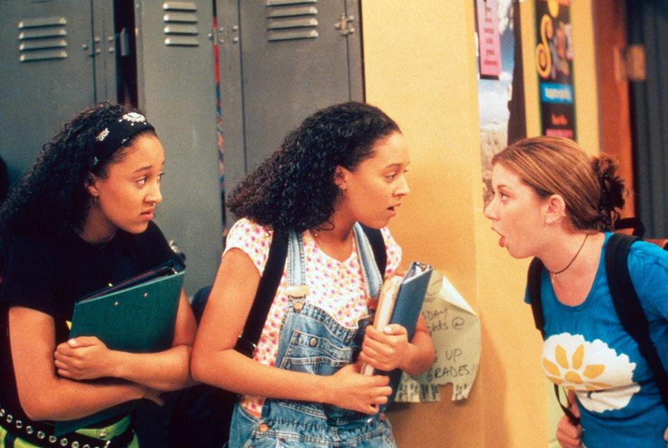 Tia and Tamera in character in sister sister talking to someone in the school hallway