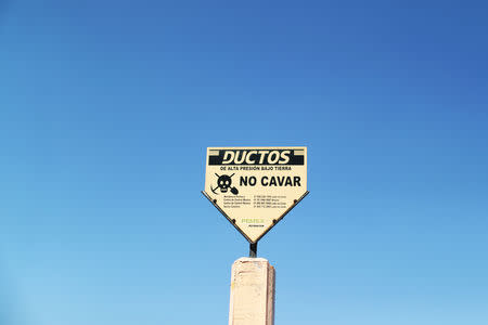 A sign warning of a pipeline is seen at the site where a fuel pipeline, ruptured by suspected oil thieves, exploded in the municipality of Tlahuelilpan, state of Hidalgo, Mexico January 22, 2019. Picture taken January 22, 2019. REUTERS/Mohammed Salem