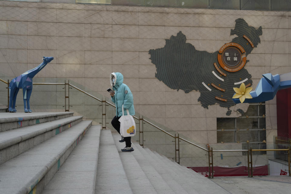 A resident walks through a partially shuttered Evergrande commercial complex in Beijing, Monday, Jan. 29, 2024. Chinese property developer China Evergrande Group on Monday was ordered to liquidate by a Hong Kong court, after the firm was unable to reach a restructuring deal with creditors. (AP Photo/Ng Han Guan)