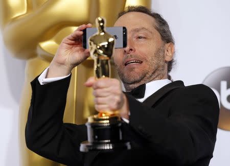 Emmanuel Lubezki poses with the Oscar for best cinematography for the film "Birdman or (The Unexpected Virture of Ignorance)," during the 87th Academy Awards in Hollywood, California February 22, 2015. REUTERS/Lucy Nicholson