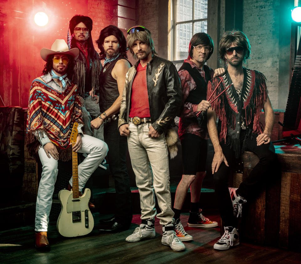 This publicity image released by Capitol Records Nashville shows members of Hot Country Knights, from left, Lead guitarist Marty Ray (“Rayro”) Roburn, steel guitarist Barry Van Ricky, lead bass player Trevor Travis, band leader Douglas (“Doug”) Douglason, percussionist Monte Montgomery, and keytar/fiddle player Terotej (“Terry”) Dvoraczekynski. The band is fronted by Douglason, the onstage alter ego for real life country star Dierks Bentley. The Hot Country Knights have been a staple of Bentley’s touring show for years, but during a break in recording and touring, Bentley produced a full album of parody songs called “The K Is Silent.” (Jim Wright/Capitol Records Nashville via AP)
