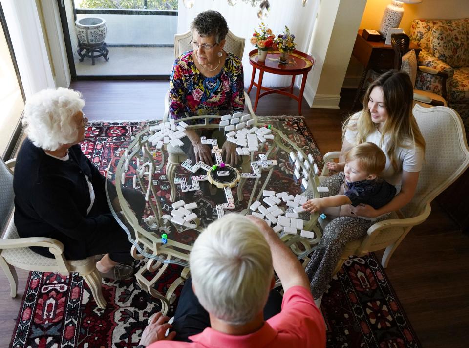 Lydia Kruesi, 100, left, plays dominos with her daughter Cindy, 76, top, grandson Scott Duval, 50, great-granddaughter Brooke Duval, 19, and great-great-grandson Greyson, 1, at Vi at Bentley Village retirement community in Naples on Monday, May 1, 2023.