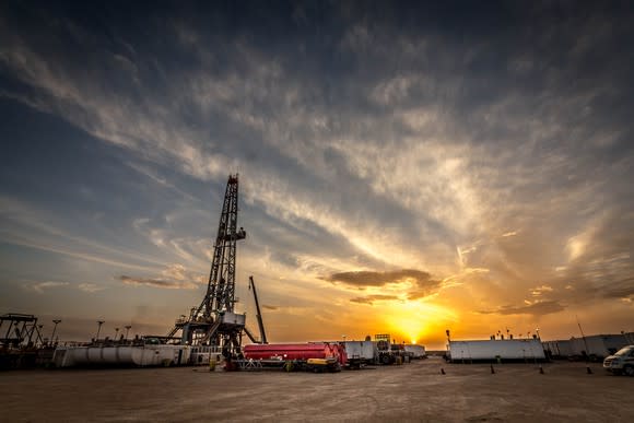 A drilling site with the sun in the background.