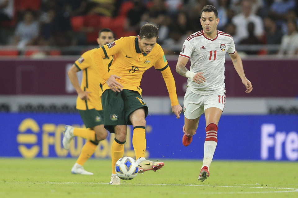 Australia's Craig Goodwin passes the ball in front of Caio Correa of the United Arab Emirates during a qualifying match between United Arab Emirates and Australia in Al Rayyan, Qatar, Tuesday, June 7 2022. (AP Photo/Hussein Sayed)