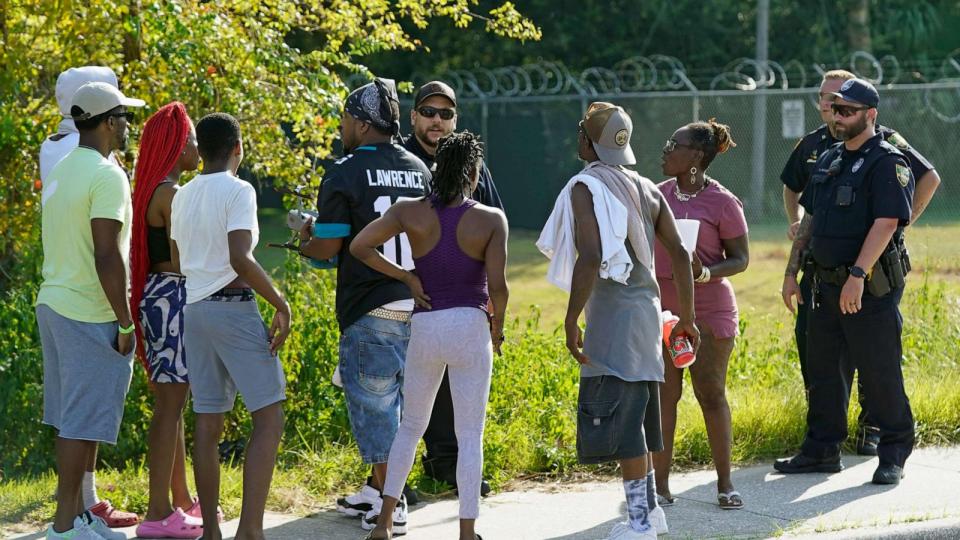 PHOTO: Residents talk with Jacksonville police officers near the scene of a mass shooting at a Dollar General store, Saturday, Aug. 26, 2023, in Jacksonville, Fla. (AP Photo/John Raoux) (John Raoux/AP)