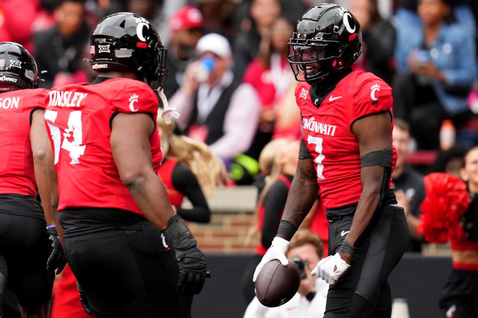 Cincinnati Bearcats tight end Chamon Metayer (7) celebrates a touchdown catch with Cincinnati Bearcats offensive lineman Dartanyan Tinsley (54) in the first quarter vs. Iowa State. UC lost to the Cyclones 30-10.