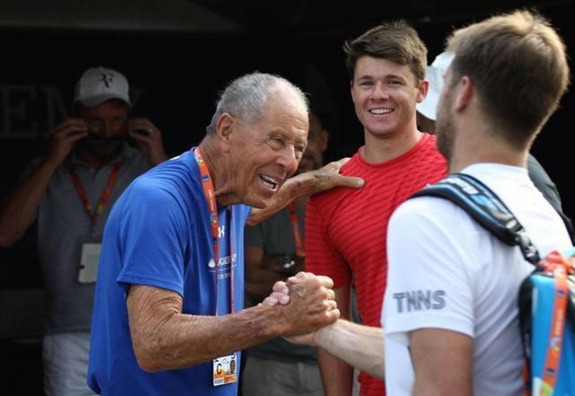 Famed tennis coach Nick Bollettieri, left, greets tennis players and brothers Christian, center, and Ryan Harrison after the two practiced on March 23, 2015, for the Miami Open in Key Biscayne, Florida.