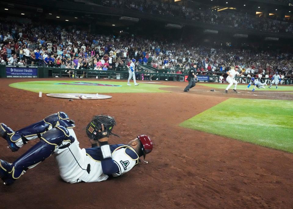 Arizona Diamondbacks catcher Gabriel Moreno (42) throws to Arizona Diamondbacks relief pitcher Kevin Ginkel (42) as Chicago Cubs’ Nico Hoerner (42) scores the tying run during the ninth inning at Chase Field in Phoenix on April 15, 2024.