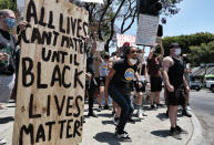 LGBTQ community members join Black Lives Matter protesters as they hold signs and chant at passing cars in an intersection in West Hollywood, Calif. on Wednesday, June 3, 2020, over the death of George Floyd, a black man who was in police custody in Minneapolis. Floyd died after being restrained by Minneapolis police officers on Memorial Day. (AP Photo/Richard Vogel)