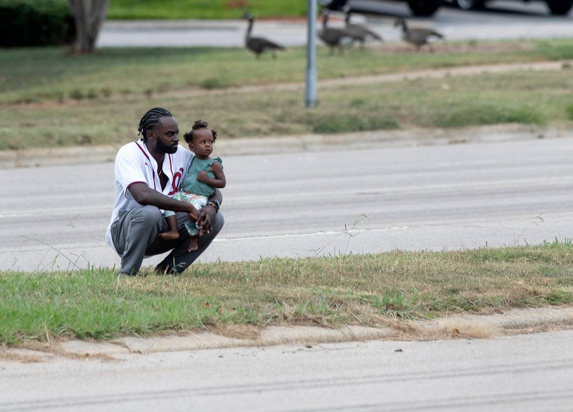 People watch from a median as the N.C. State Highway Patrols Caisson Unit carries the casket of slain Wake County Sheriffs Deputy Ned Byrd down Glenwood Avenue on Friday, Aug. 19, 2022, in Raleigh, N.C. Byrd was found dead with multiple gunshot wounds early Friday morning, Aug. 12 in southeastern Wake County.