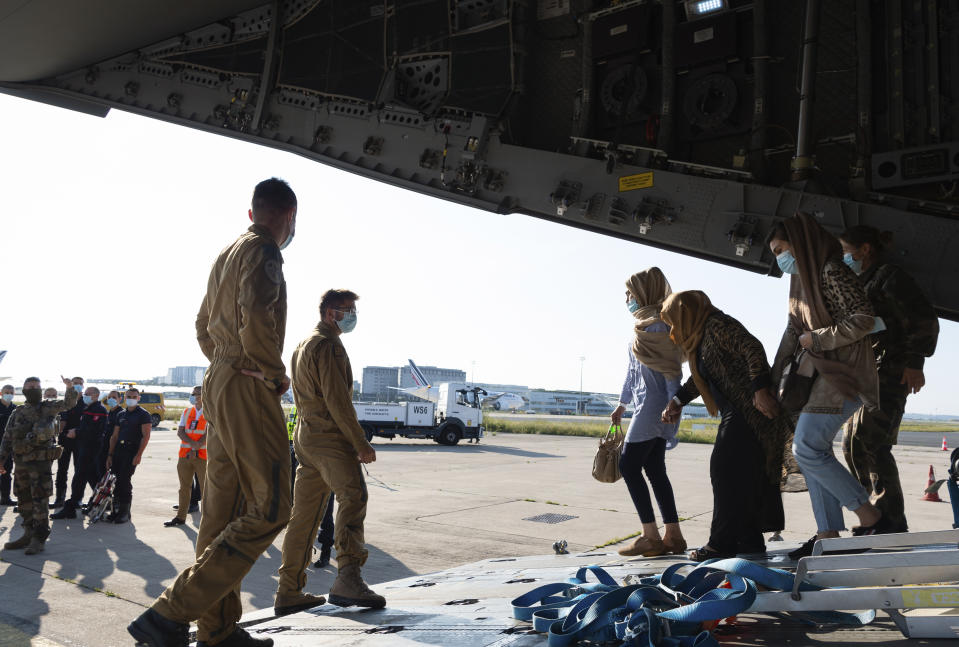 En esta foto distribuida el jueves 26 de agosto de 2021 por el Ejército francés, refugiados afganos llegan en un avión militar al aeropuerto de Roissy, al norte de París, el miércoles 25 de agosto de 2021. Al menos 1720 afganos y un centenar de franceses han sido evacuados por Francia desde el inicio de la operación la semana pasada. (Eric Cadiou/Estado Mayor de las Fuerzas Armadas Francesas via AP)